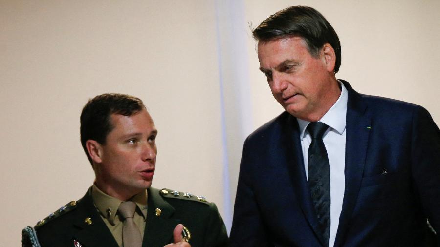 18.jun.2019 - Mauro Cid, então ajudante de ordens, conversa com Bolsonaro após uma reunião no Palácio do Planalto Imagem: 18.jun.2019 - Adriano Machado/Reuters