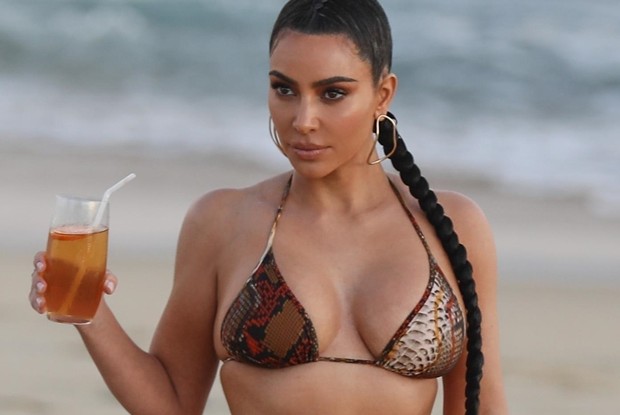 De biquíni, Kim Kardashian grava reality show em praia em Los Angeles