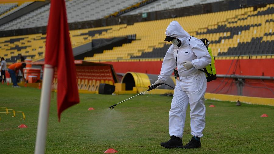 Funcionário desinfecta Estádio Monumental de Guayaquil antes de Barcelona (EQU) x Flamengo pela Copa Libertadores 2020 - Imagem: RODRIGO BUENDIA / POOL / AFP
