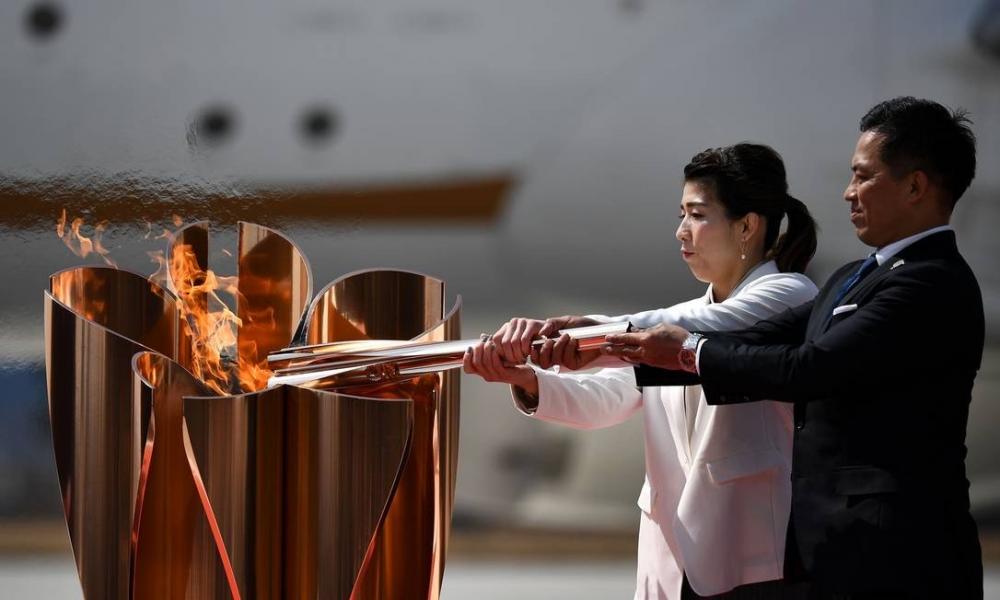 Os atletas japoneses Saori Yoshida e Tadahiro Nomura acendem uma pira olímpica, em Higashimatsushima, em 20 de março de 2020: cerimônia teve programação reduzida para evitar a transmissão do novo coronavírus Foto: PHILIP FONG / AFP