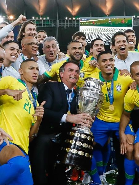 O presidente Jair Bolsonaro posa com a taça da Copa América e a seleção brasileira, no Maracanã, em 2019 (Carolina Antunes/PR) Imagem: Reprodução / Internet
