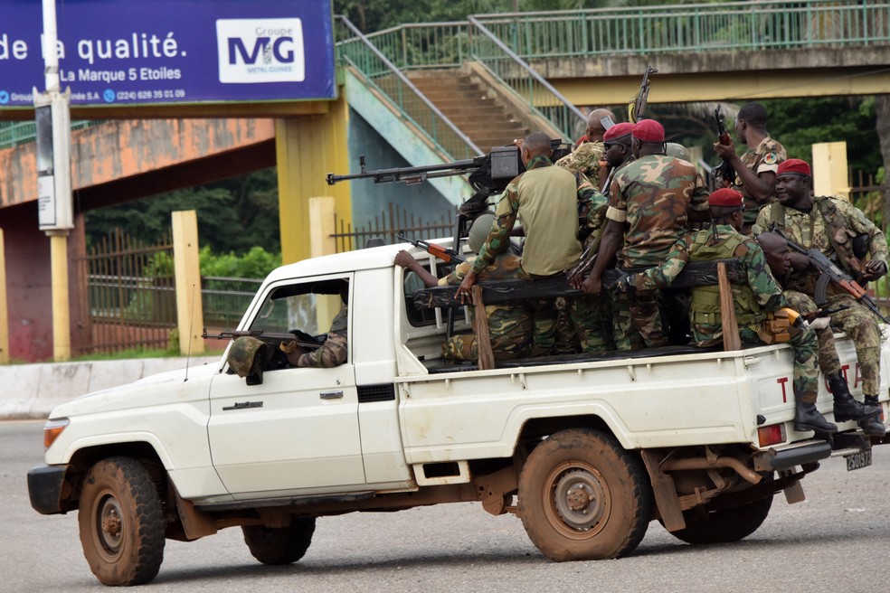 Militares de Guiné em caçamba de caminhonete passam pelo centro de Conakry depois do disparo de tiros no palácio presidencial — Foto: CELLOU BINANI / AFP